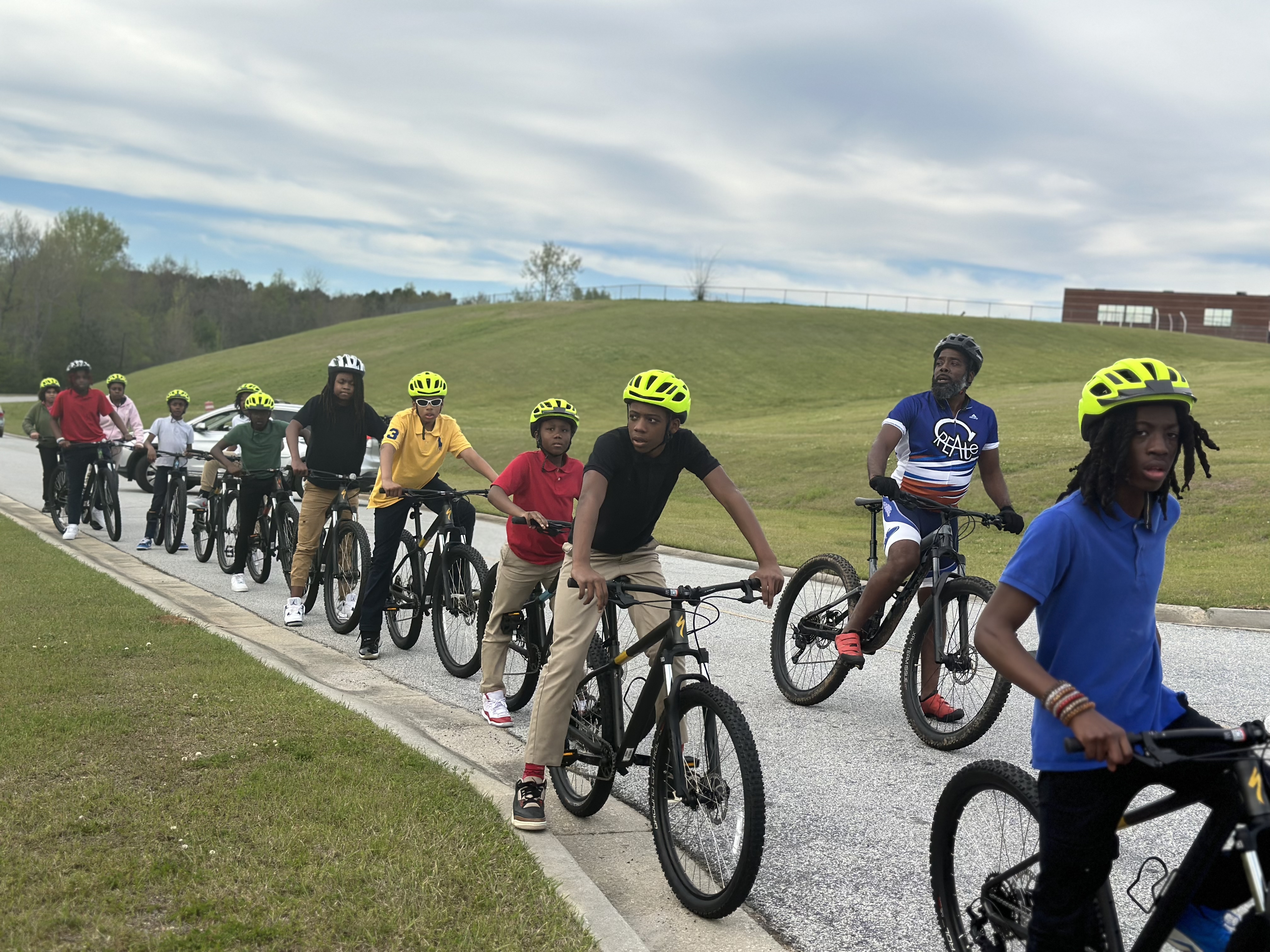 A group of kids lines up with bikes beside an instructor
